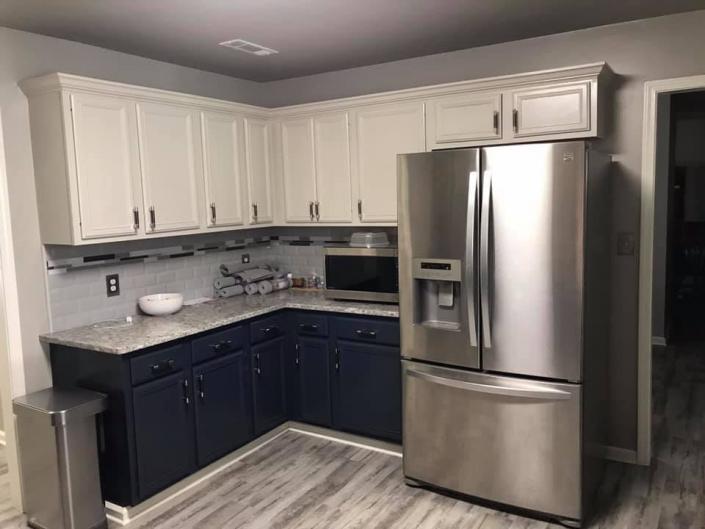 White cabinets paired with navy blue adds depth and high-end appeal to this modern-style kitchen. 