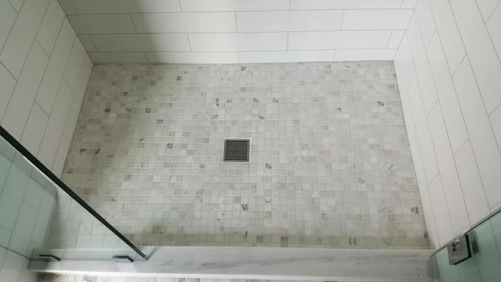 We've added depth and a unique flair to this bathroom shower with this multi-colored tile flooring. 