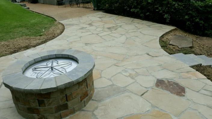 Complete with a gorgeous fire pit, this natural stone patio is absolutely breathtaking! 